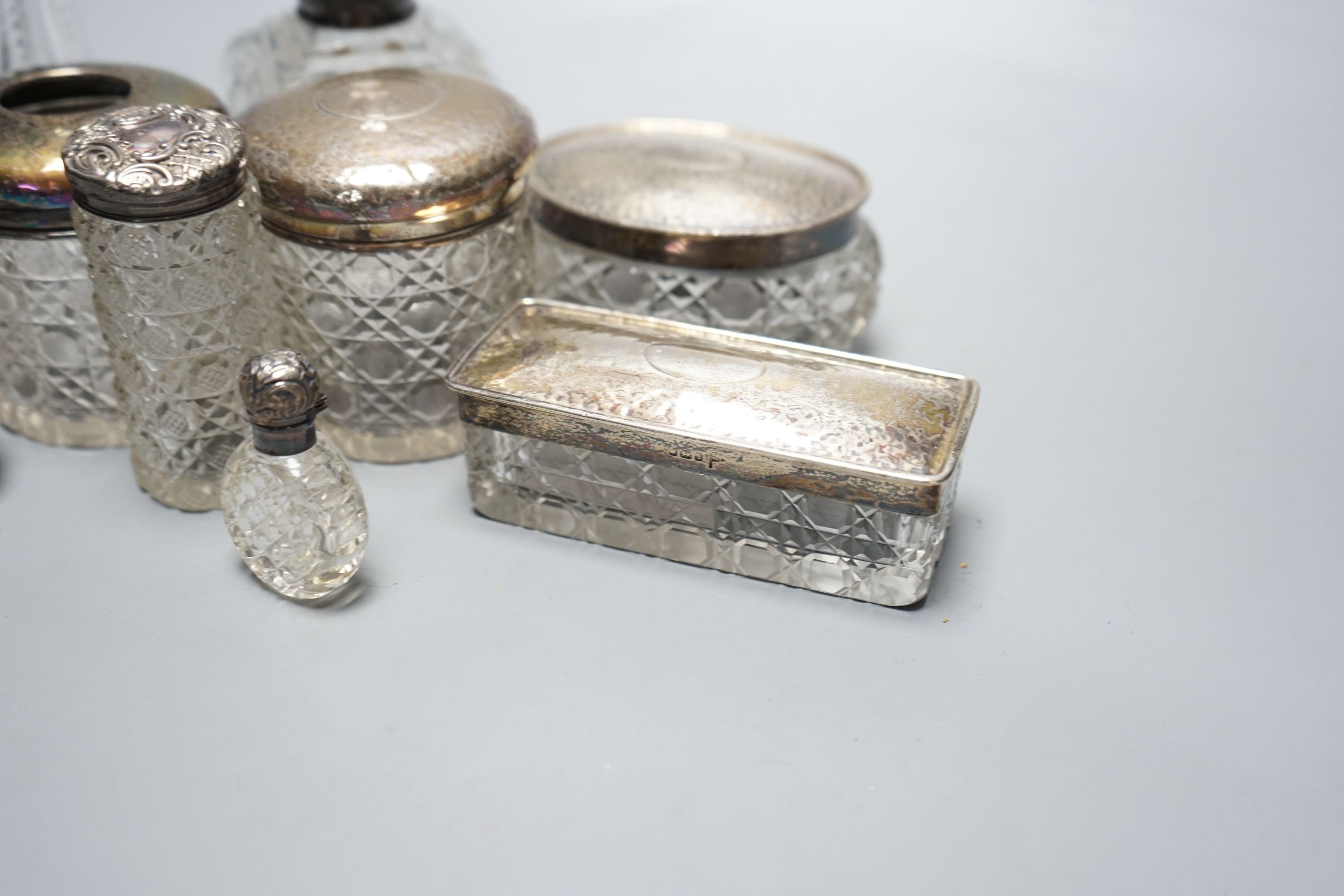 Two silver mounted cut glass scent bottles, including enamel(a.f.) and eight various dressing table items with silver lids.